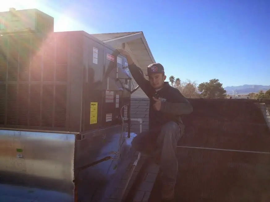 HVAC technician performing Air Duct Repair on a rooftop unit in Lake St. Louis